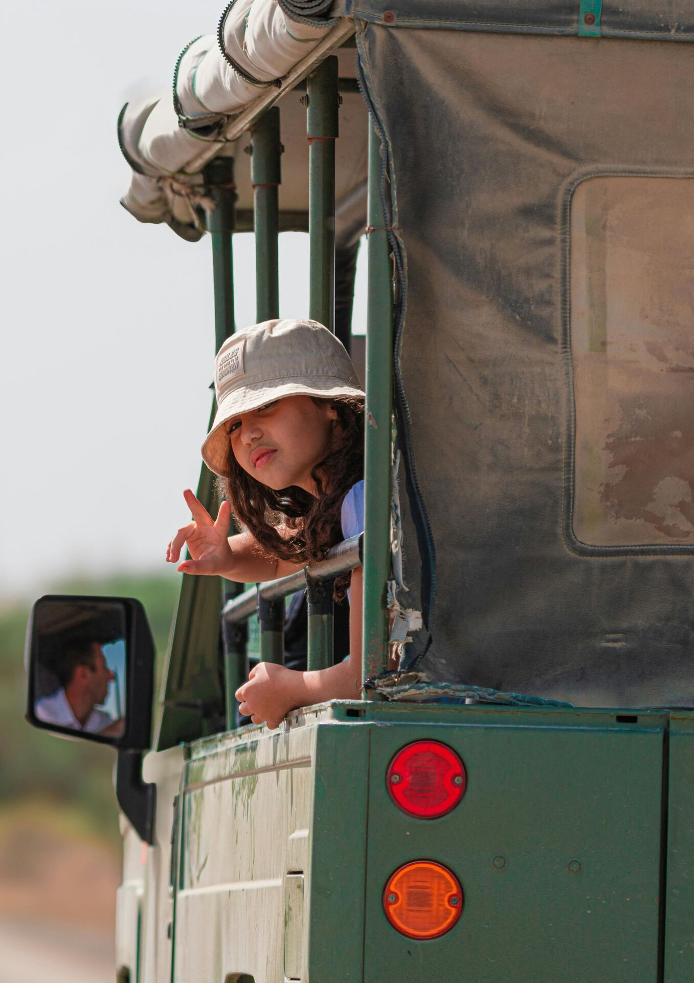 Petite fille en safari dans la savane tanzanienne — voyage en famille avec Safari & Wellness Africa